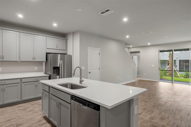 kitchen featuring stainless steel appliances, a sink, and gray cabinetry