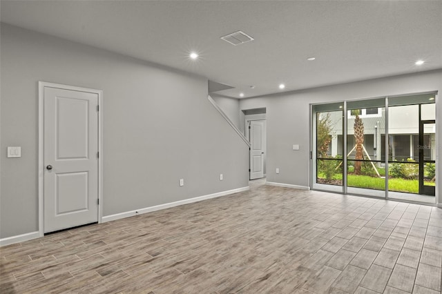 empty room with visible vents, baseboards, light wood-style flooring, and recessed lighting