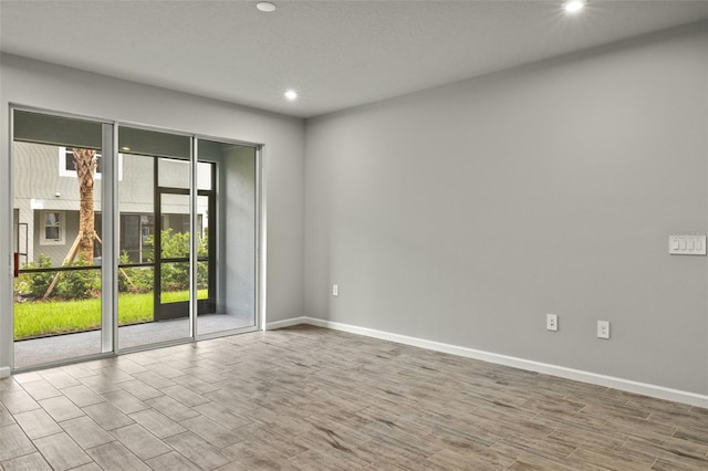 empty room with baseboards and wood finished floors