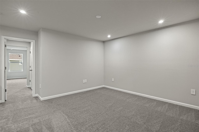 empty room featuring carpet, baseboards, and recessed lighting