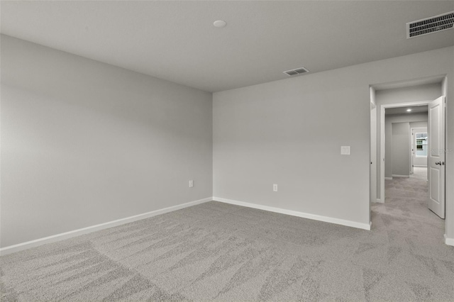 carpeted empty room featuring visible vents and baseboards