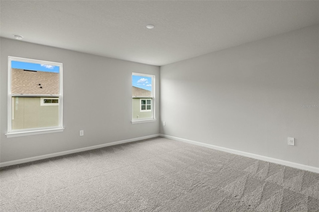 carpeted spare room with baseboards