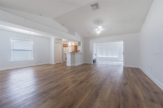 unfurnished living room featuring ceiling fan, vaulted ceiling, and dark wood-type flooring