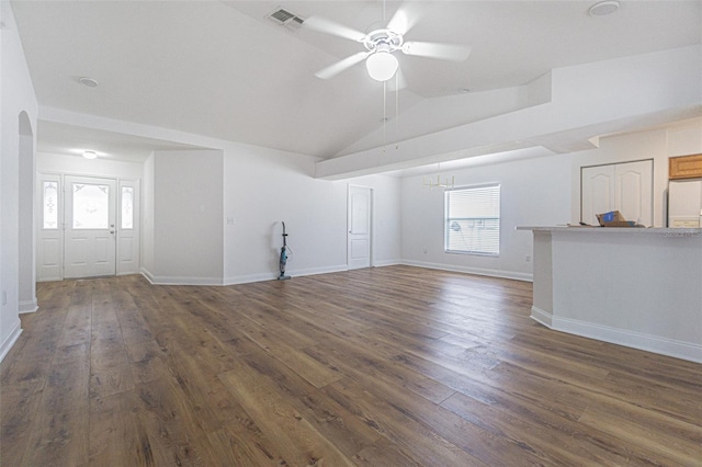 unfurnished living room with a healthy amount of sunlight, vaulted ceiling, ceiling fan, and dark wood-type flooring