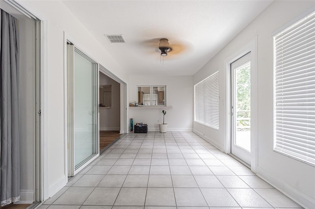 unfurnished living room featuring ceiling fan and light tile patterned flooring