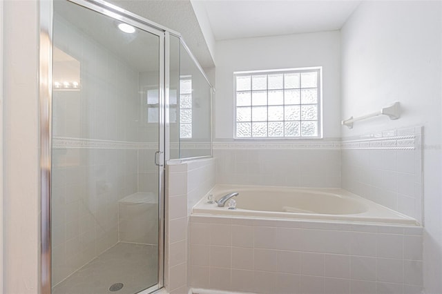 bathroom featuring shower with separate bathtub