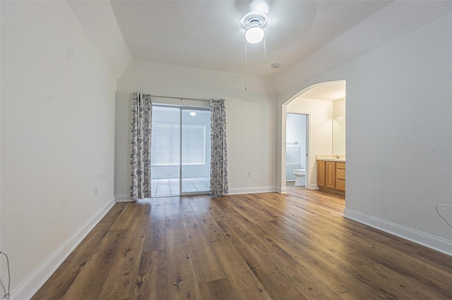 unfurnished bedroom featuring dark hardwood / wood-style floors, ceiling fan, and ensuite bath