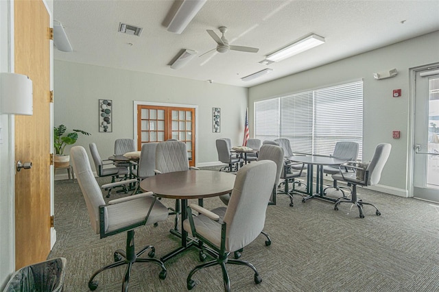 dining area featuring ceiling fan, carpet flooring, and a textured ceiling