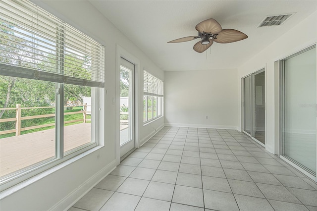 unfurnished sunroom featuring ceiling fan