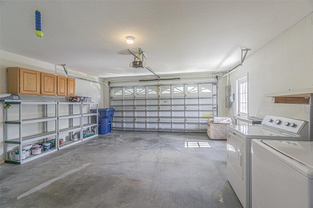 garage featuring electric panel, a garage door opener, and washing machine and clothes dryer