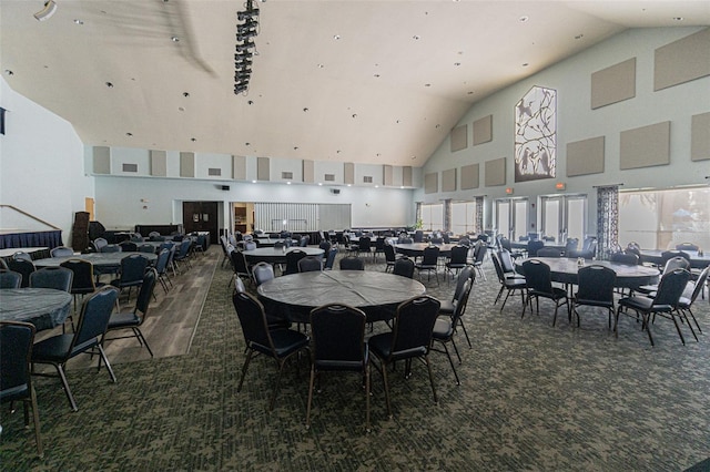 dining space with high vaulted ceiling and dark carpet