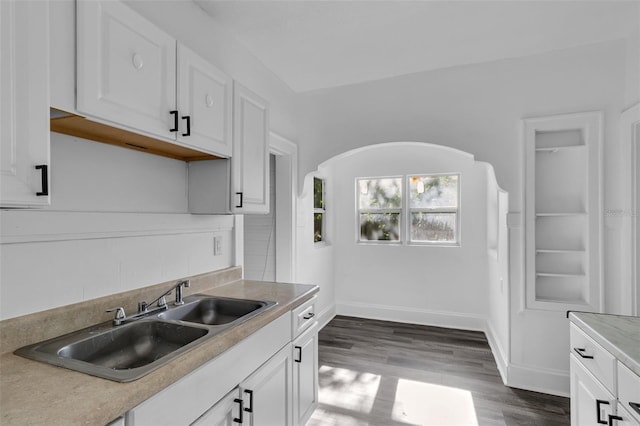 kitchen with sink, white cabinetry, and wood-type flooring