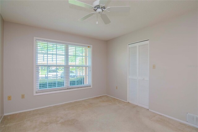 unfurnished room with ceiling fan and light colored carpet