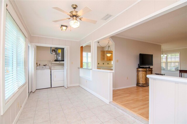 interior space with light tile patterned flooring, plenty of natural light, and crown molding