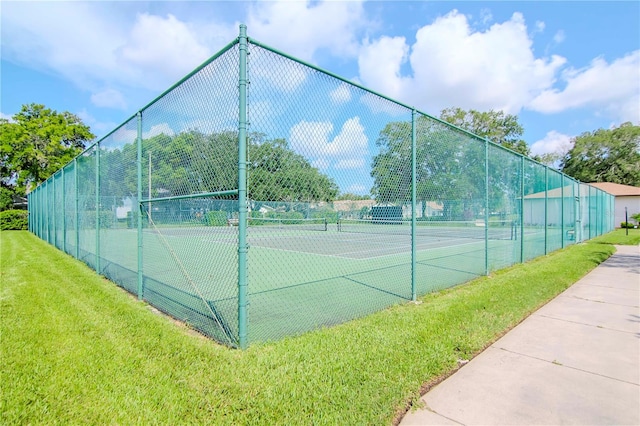 view of sport court with a lawn