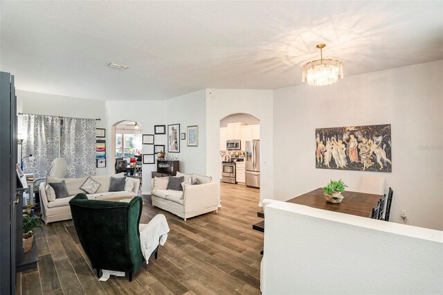 living room with a chandelier and dark hardwood / wood-style flooring