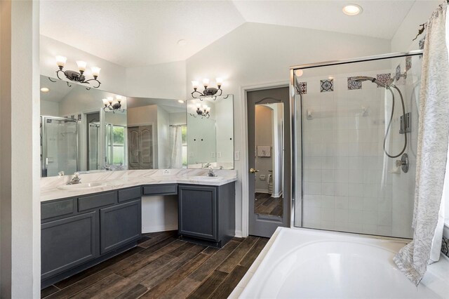 bathroom with lofted ceiling, vanity, hardwood / wood-style floors, and shower with separate bathtub