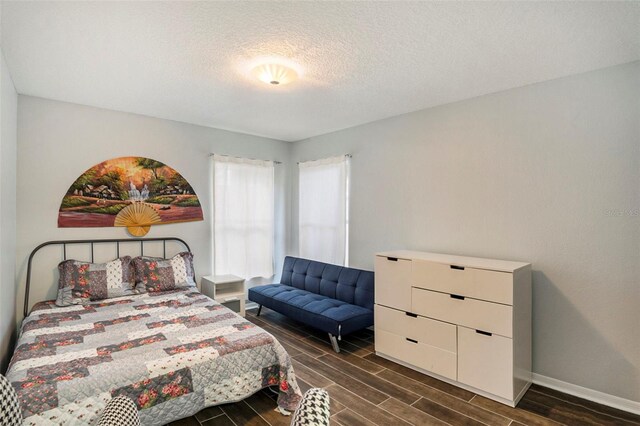 bedroom featuring a textured ceiling and dark wood-type flooring