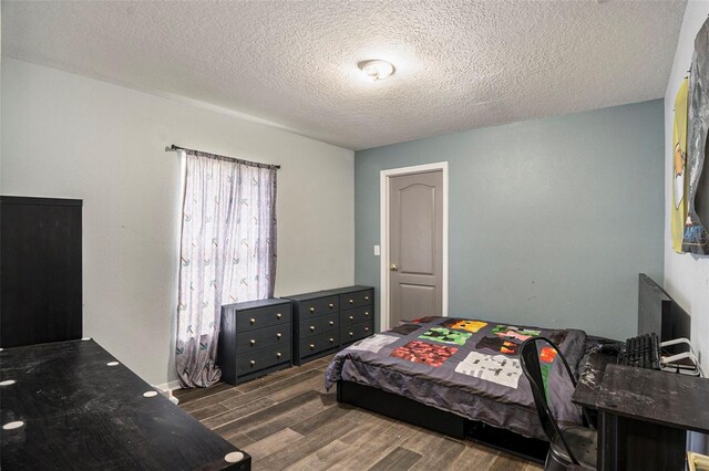 bedroom featuring dark wood-type flooring and a textured ceiling