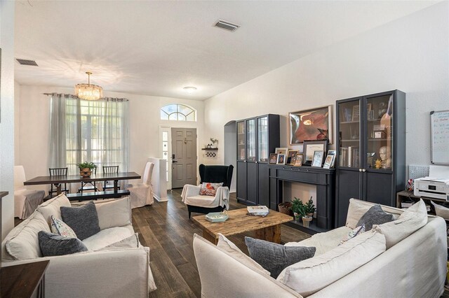 living room with dark wood-type flooring and a notable chandelier