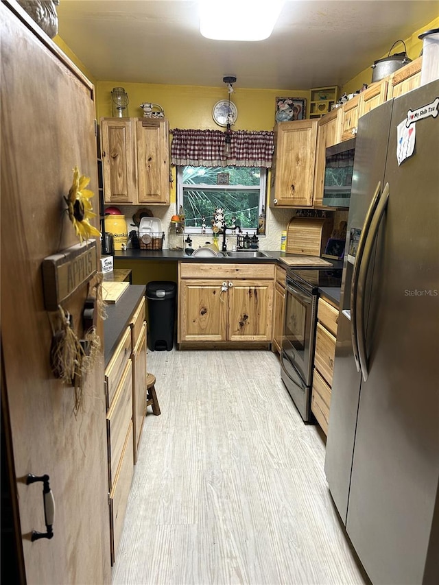 kitchen featuring light hardwood / wood-style flooring, appliances with stainless steel finishes, and sink