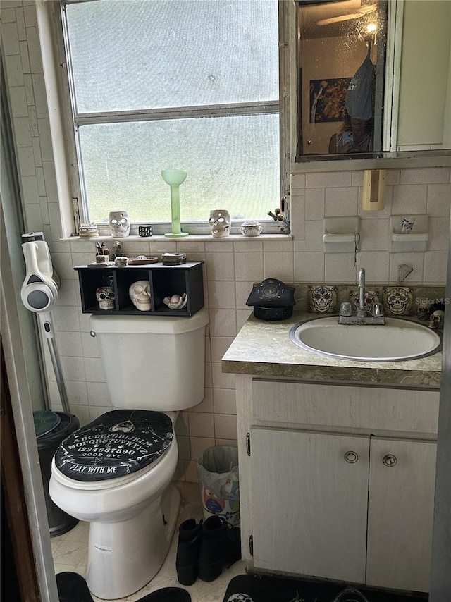 bathroom featuring vanity, decorative backsplash, tile walls, and toilet