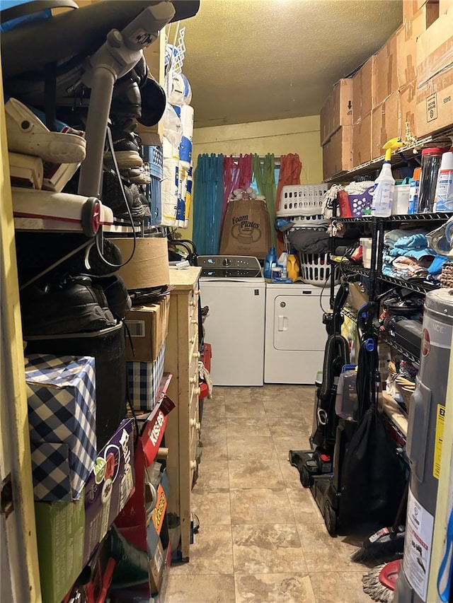 storage area with washer and clothes dryer and water heater