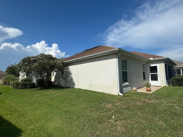 view of side of home with a yard