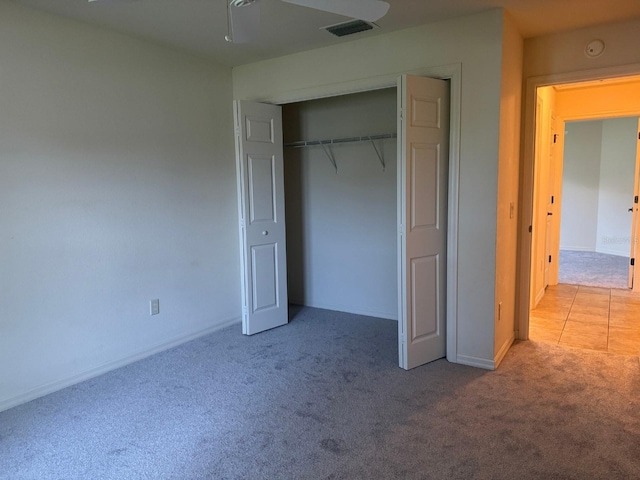 unfurnished bedroom with light carpet, a closet, and ceiling fan