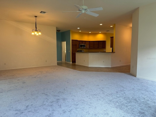 unfurnished living room featuring ceiling fan with notable chandelier and carpet floors