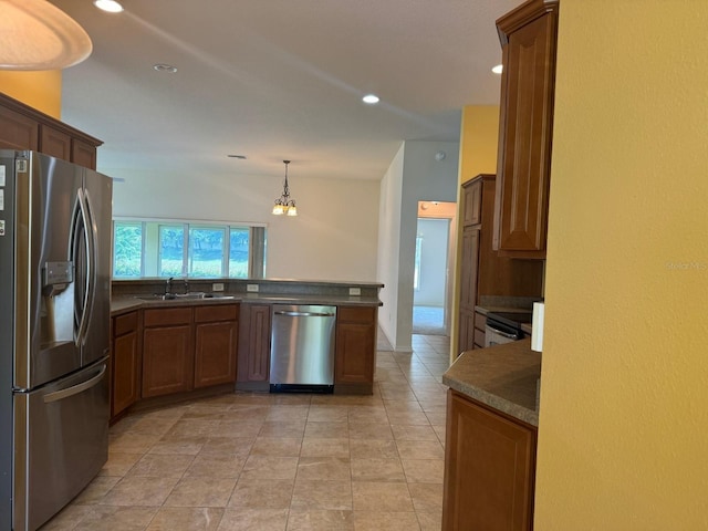 kitchen featuring kitchen peninsula, appliances with stainless steel finishes, sink, pendant lighting, and light tile patterned flooring