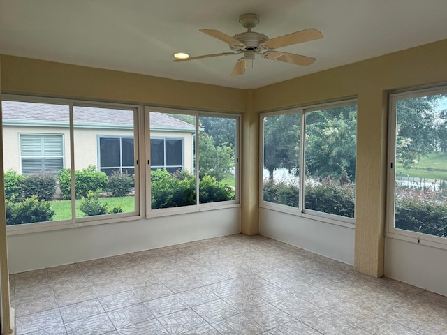 unfurnished sunroom with ceiling fan