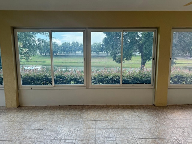 unfurnished sunroom featuring a water view and a wealth of natural light