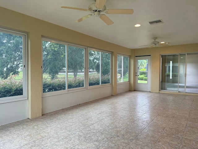 unfurnished sunroom with ceiling fan