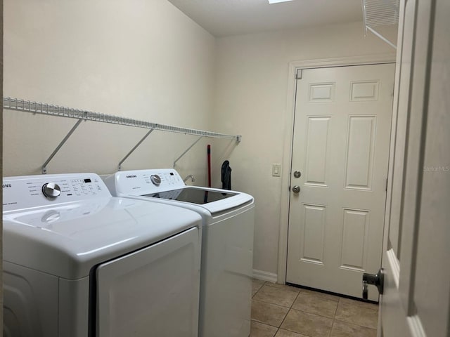 clothes washing area featuring light tile patterned floors and washing machine and dryer