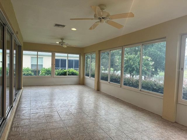 unfurnished sunroom with ceiling fan