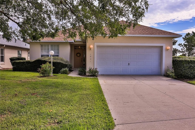 single story home with a garage and a front lawn