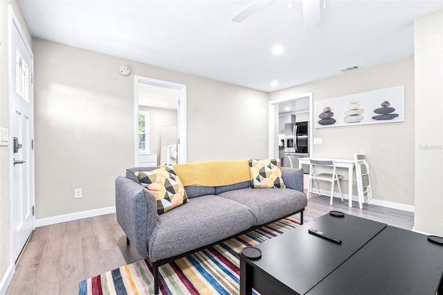 living room with ceiling fan and light hardwood / wood-style flooring