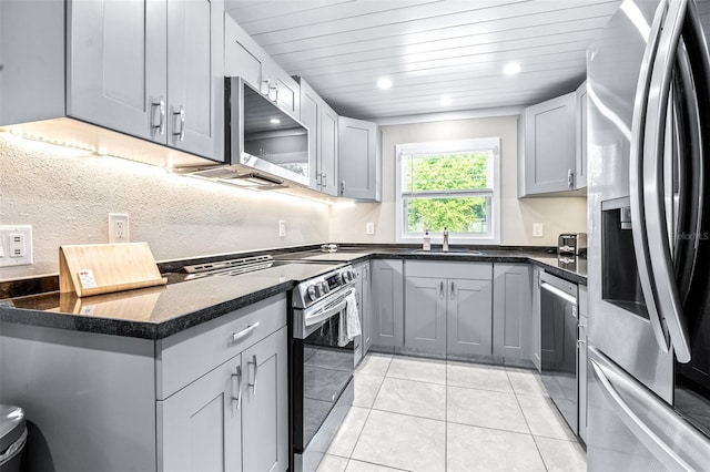 kitchen featuring stainless steel appliances, sink, gray cabinetry, and light tile patterned floors