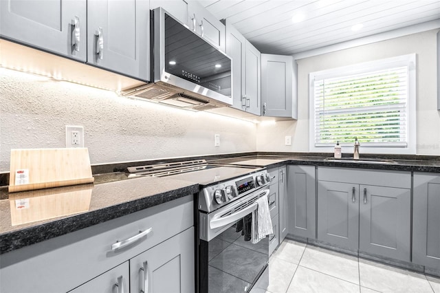 kitchen featuring gray cabinetry, sink, light tile patterned flooring, and appliances with stainless steel finishes