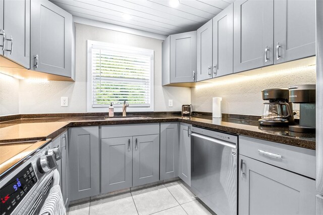 kitchen with sink, light tile patterned floors, gray cabinets, and appliances with stainless steel finishes