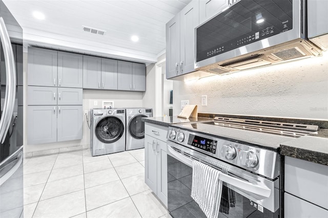 washroom featuring light tile patterned flooring and washer and clothes dryer