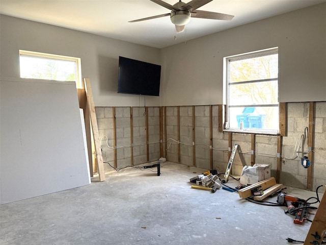 interior space featuring concrete floors, ceiling fan, and a healthy amount of sunlight