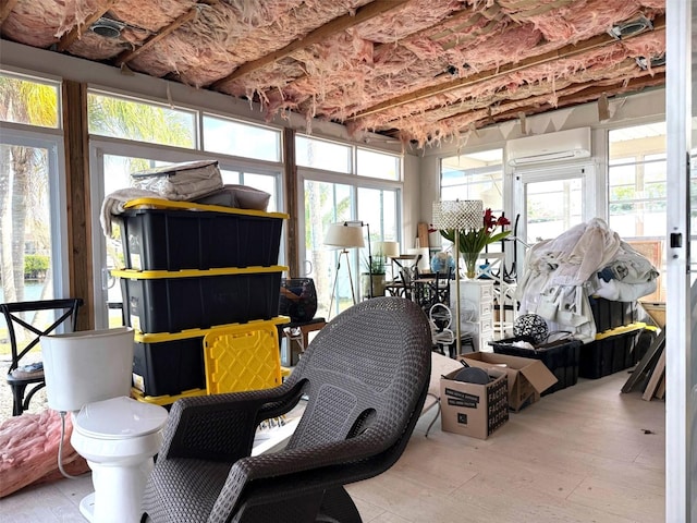 sunroom / solarium featuring a wall mounted AC and a healthy amount of sunlight