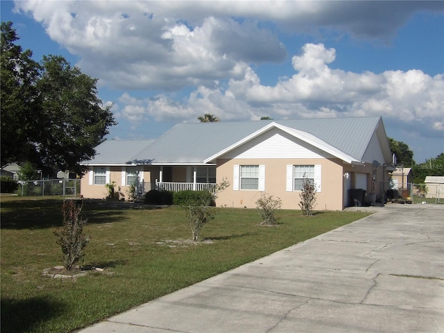 single story home featuring a garage, a porch, and a front yard