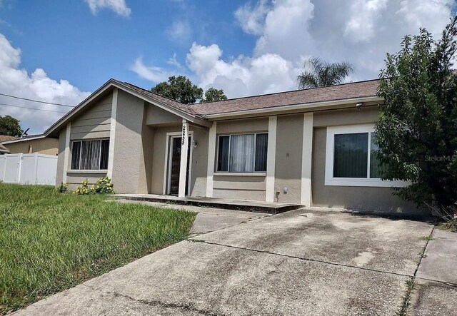 ranch-style house with a patio area and a front lawn