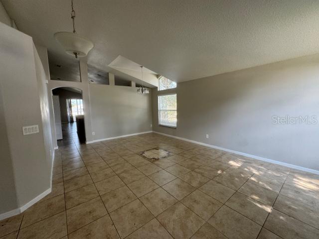 empty room with a textured ceiling and tile patterned floors