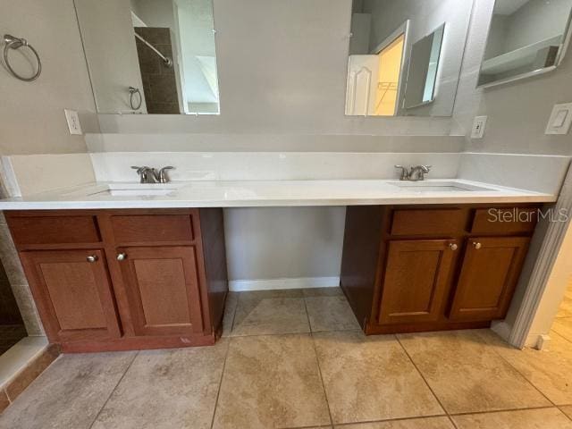 bathroom with tile patterned floors, vanity, and tiled shower