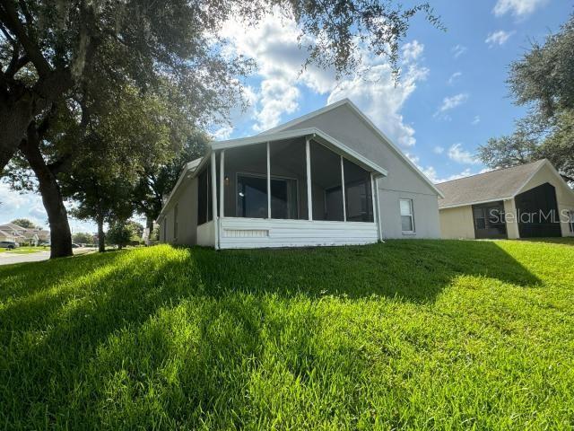 view of property exterior with a sunroom and a yard