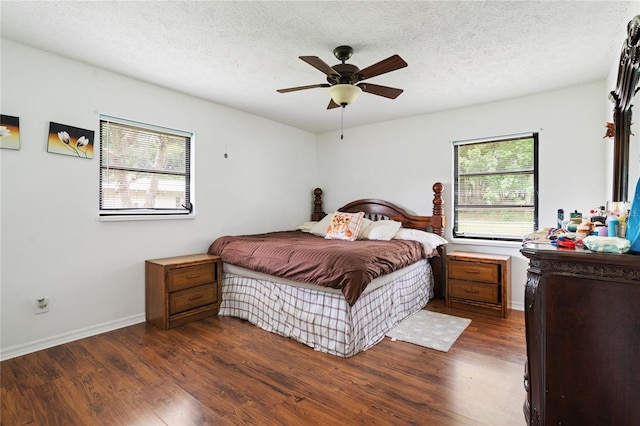 bedroom featuring ceiling fan, dark hardwood / wood-style flooring, and a textured ceiling